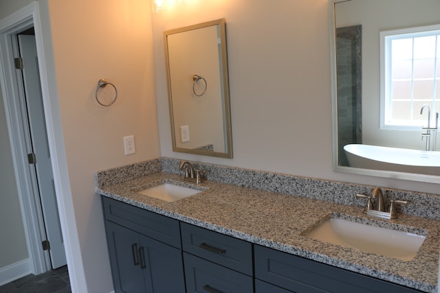 bathroom with dual vanity, plenty of natural light, and tile patterned flooring