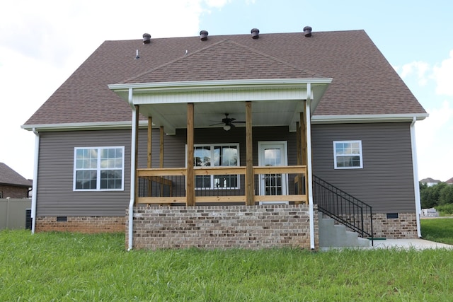 back of property featuring ceiling fan and a lawn