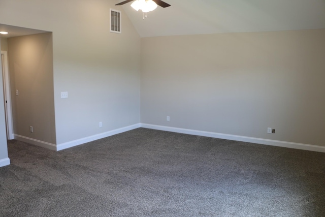 empty room with dark carpet, vaulted ceiling, and ceiling fan