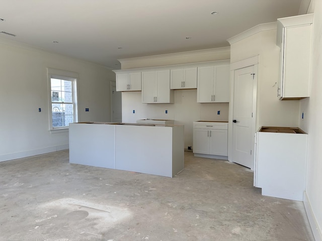 kitchen with crown molding, a center island, and white cabinets