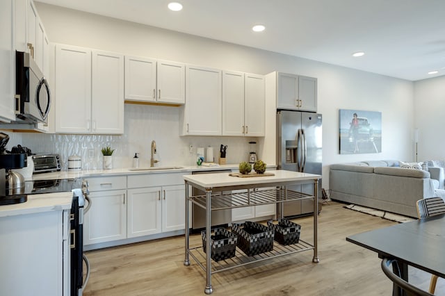 kitchen featuring white cabinetry, light wood-type flooring, sink, and stainless steel appliances