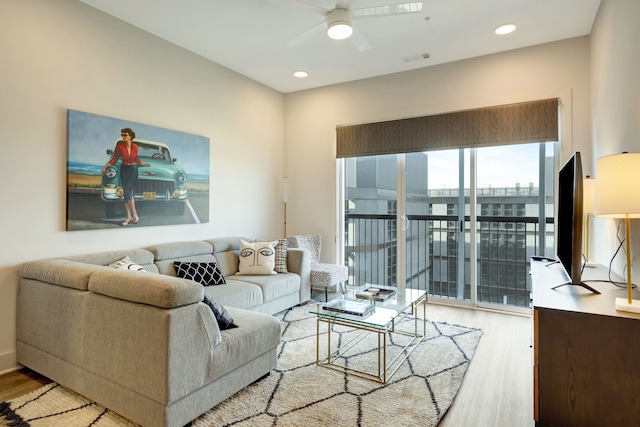 living room with ceiling fan and light hardwood / wood-style flooring