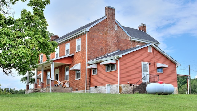 rear view of house with a porch and a yard