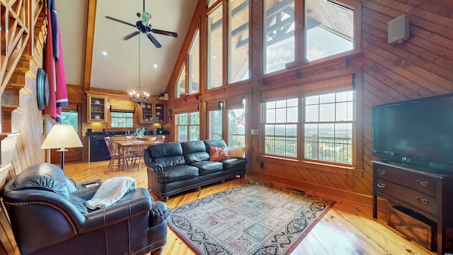 living room with a healthy amount of sunlight, high vaulted ceiling, and beam ceiling