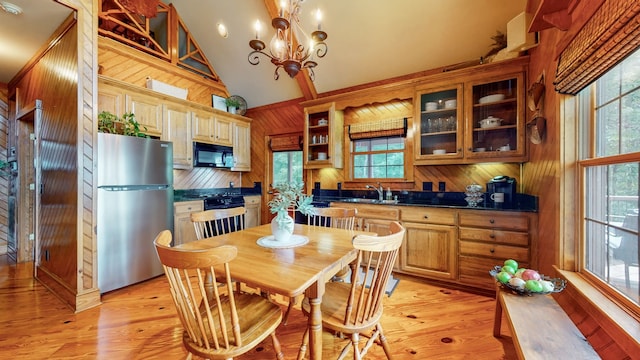 kitchen featuring stainless steel fridge, stove, a chandelier, and light wood-type flooring