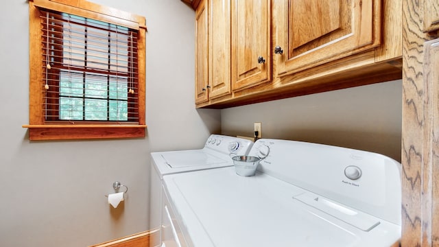 washroom with cabinets and washer and dryer