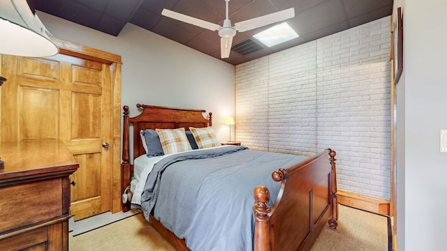 bedroom featuring brick wall, light carpet, and ceiling fan