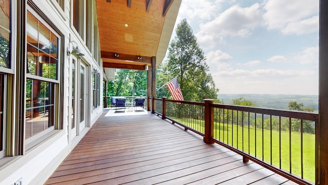 wooden terrace featuring a lawn