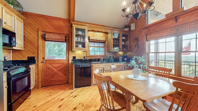 kitchen featuring light wood-type flooring, a notable chandelier, sink, high vaulted ceiling, and black appliances