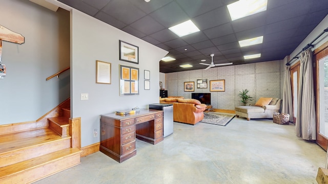 office space featuring ceiling fan and a drop ceiling