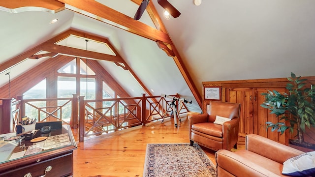 living room featuring hardwood / wood-style floors, ceiling fan, and vaulted ceiling with beams