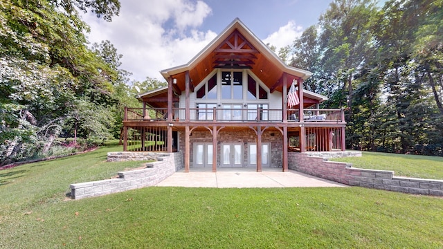 rear view of property with a lawn, a patio area, and a wooden deck