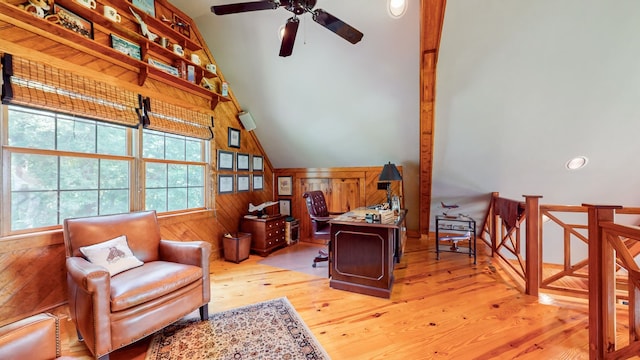 office area with ceiling fan, wooden walls, lofted ceiling, and light wood-type flooring