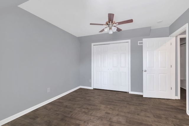 unfurnished bedroom featuring dark wood-type flooring, ceiling fan, and a closet