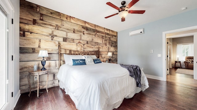 bedroom with a wall unit AC, dark hardwood / wood-style flooring, and ceiling fan