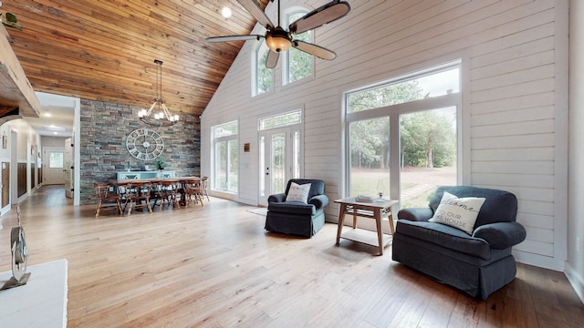 living room with high vaulted ceiling, light hardwood / wood-style flooring, and a wealth of natural light