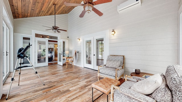 interior space with french doors, ceiling fan, a wall mounted AC, a healthy amount of sunlight, and lofted ceiling