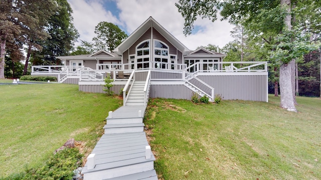 rear view of house featuring a wooden deck and a yard