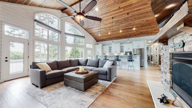 living room featuring high vaulted ceiling, wooden ceiling, and a healthy amount of sunlight