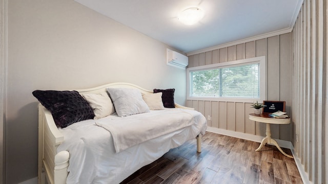 bedroom featuring crown molding, hardwood / wood-style floors, and a wall unit AC