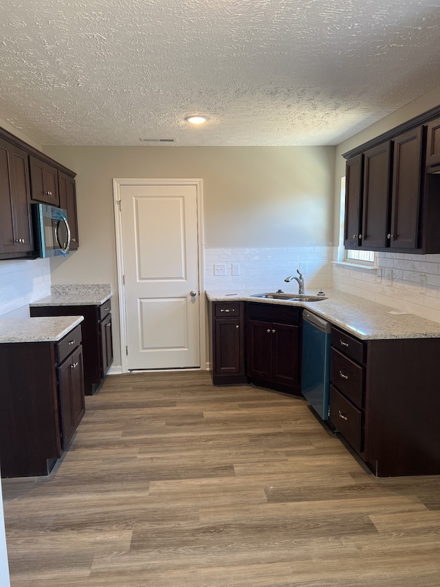 kitchen with sink, light hardwood / wood-style flooring, a textured ceiling, dark brown cabinetry, and stainless steel appliances