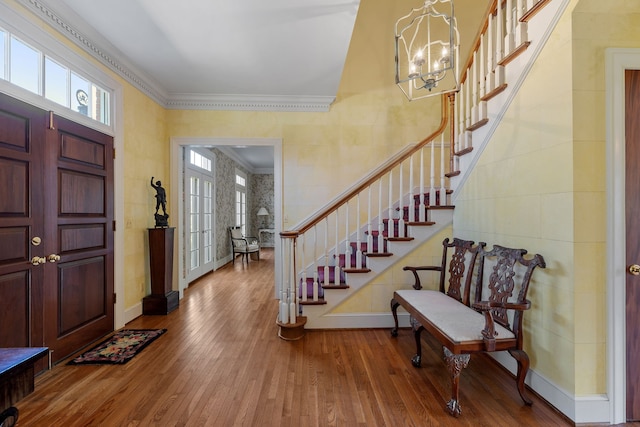 foyer entrance featuring crown molding, an inviting chandelier, and hardwood / wood-style flooring