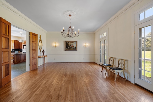 empty room featuring an inviting chandelier, a healthy amount of sunlight, and wood-type flooring