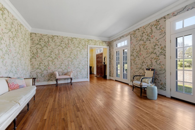 living area featuring ornamental molding and light wood-type flooring