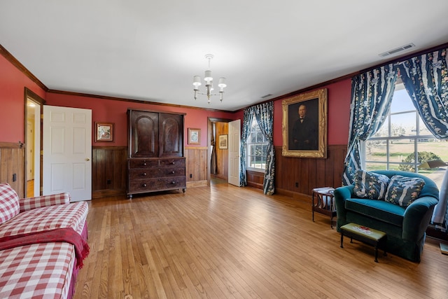 living room featuring a healthy amount of sunlight, a notable chandelier, and light wood-type flooring