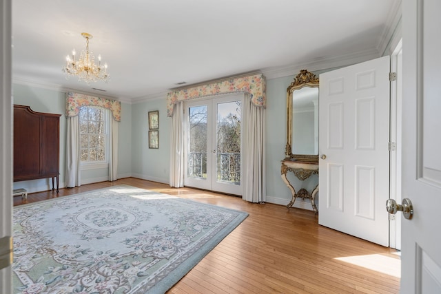 interior space with french doors, ornamental molding, a notable chandelier, and light hardwood / wood-style flooring