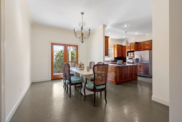 dining room featuring a notable chandelier, sink, dark tile floors, ornamental molding, and french doors