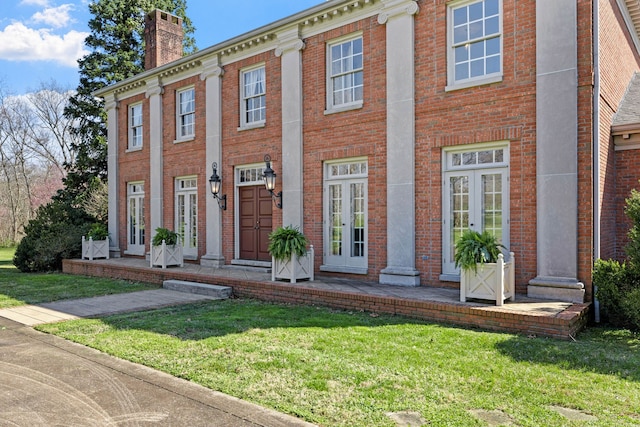 view of front of property with a front yard and french doors