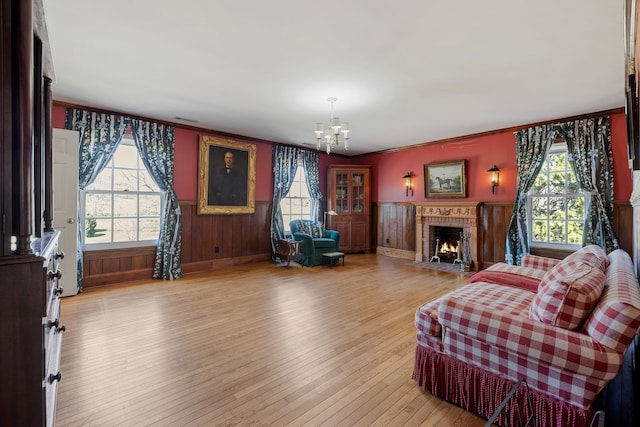 living room featuring a fireplace, an inviting chandelier, and light wood-type flooring