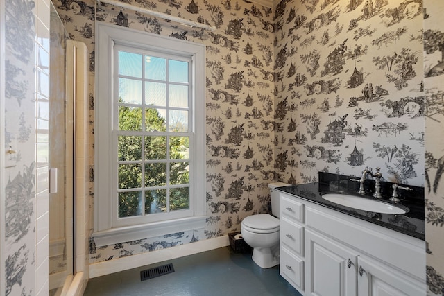 bathroom with toilet, a shower with door, and vanity