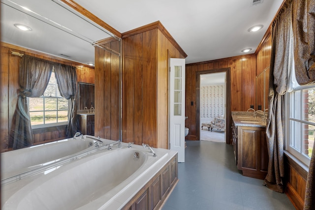 bathroom featuring wood walls, tile floors, vanity, and a tub