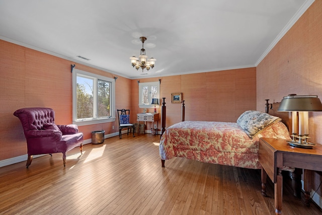 bedroom featuring crown molding, hardwood / wood-style flooring, and an inviting chandelier