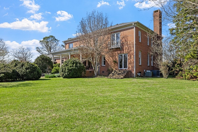 back of property featuring central AC unit and a yard