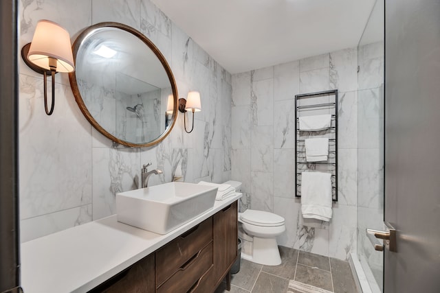 bathroom featuring tile walls, toilet, vanity, and tile floors