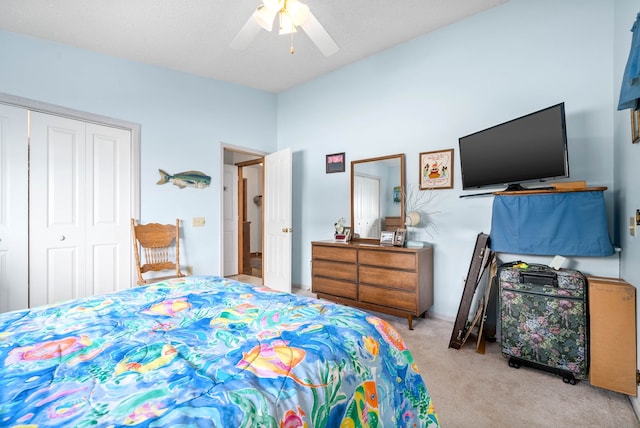 carpeted bedroom featuring ceiling fan and a closet