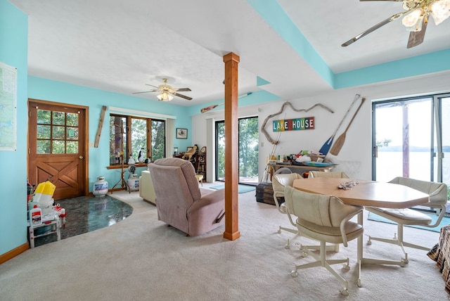 living room with a water view, ceiling fan, and light colored carpet