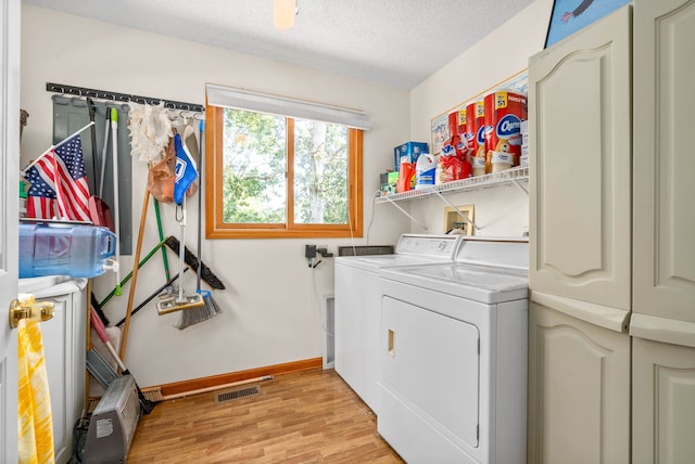 laundry area with washer and clothes dryer, light hardwood / wood-style floors, and a textured ceiling