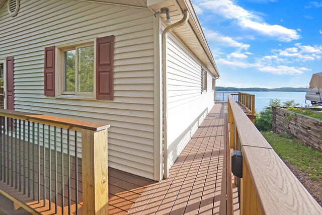 view of property exterior featuring a deck with water view