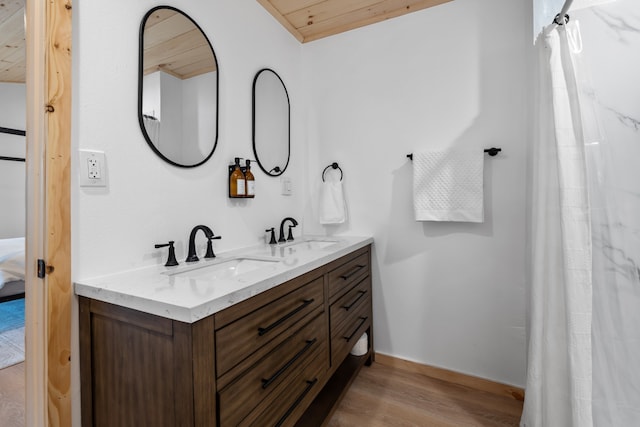 bathroom with dual sinks, wood ceiling, oversized vanity, and hardwood / wood-style flooring