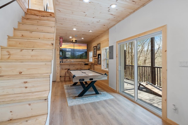 rec room with wooden walls, wooden ceiling, and light hardwood / wood-style floors