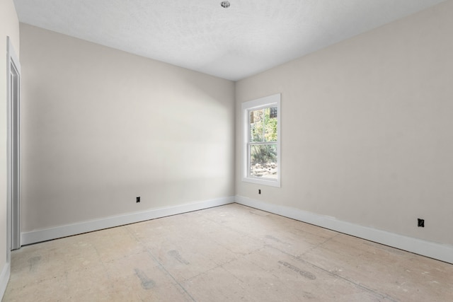 unfurnished room with a textured ceiling