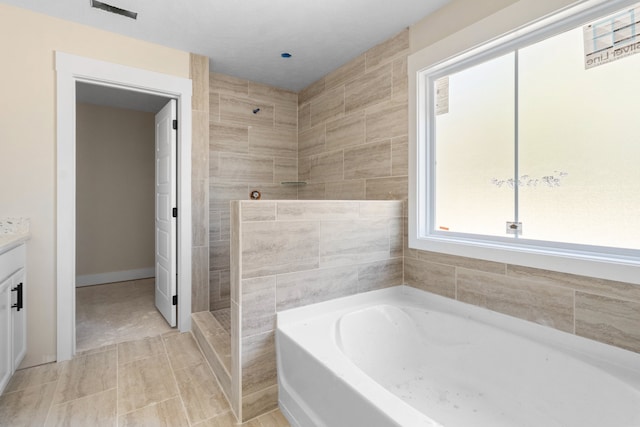 bathroom with vanity, tile patterned floors, plus walk in shower, and tile walls