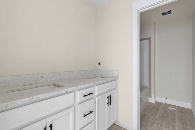 bathroom with vanity and a washtub