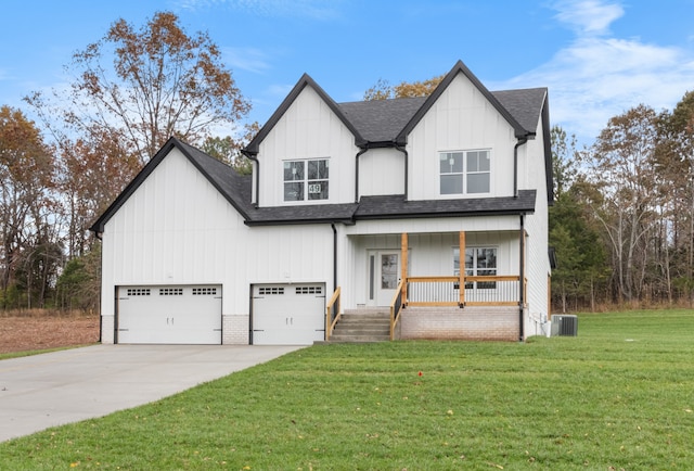 view of front of property with a garage, cooling unit, covered porch, and a front lawn