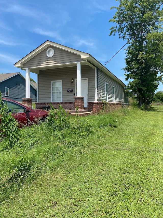 view of front of house with a front yard and a porch