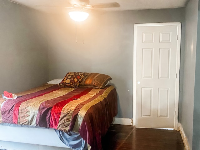 bedroom with dark hardwood / wood-style flooring and ceiling fan